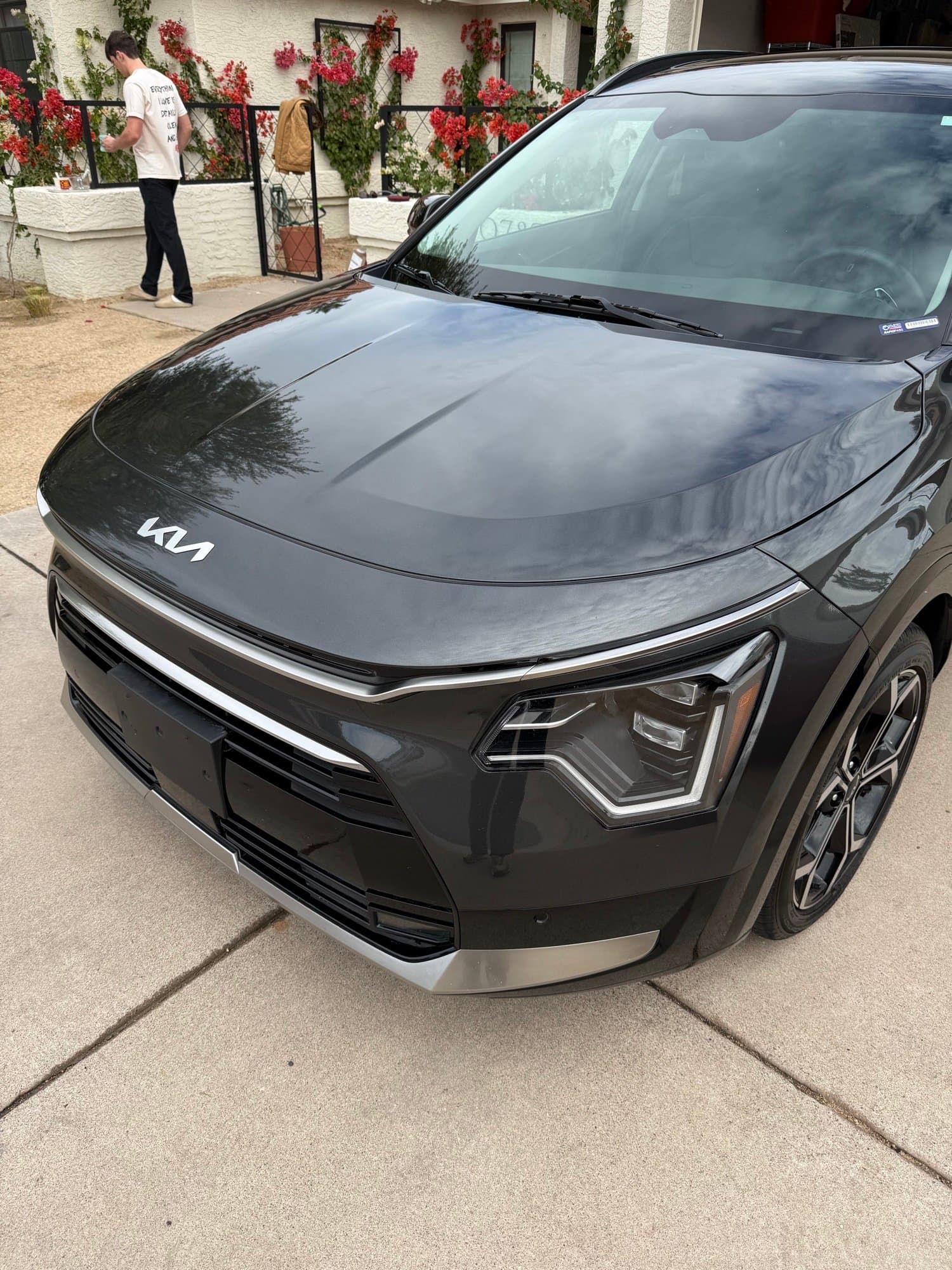 Freshly detailed black Kia with a deep, glossy ceramic-coated finish in a Scottsdale driveway